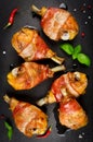 Bacon wrapped chicken legs on a black background Royalty Free Stock Photo