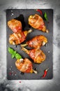 Bacon wrapped chicken legs on a black background Royalty Free Stock Photo