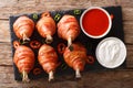 Bacon Wrapped Chicken Lollipops with sauces close-up. Horizontal top view Royalty Free Stock Photo