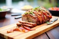 bacon-wrapped meatloaf sliced on a wooden board