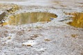 The bad asphalted road with a big pothole filled with water. Dangerous destroyed roadbed. Mirror reflections of autumn trees. Royalty Free Stock Photo