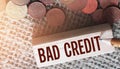 Bad credit text on wooden block and coins on burlap canvas. Crisis times unpaid loand and credits financial business