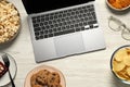 Bad eating habits at workplace. Laptop, glasses and different snacks on white wooden table, flat lay