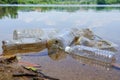 Bad environmental habit of improper disposal of non-biodegradable PVC cups and bottles in a lake. Selective focus.