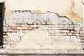 Bad foundation base on old house or building cracked plaster facade wall with brick background Royalty Free Stock Photo