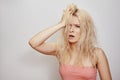 Beautiful woman with messed up hair. Unhappy grimacing face. Blond bleaching hairstyle with problem brittle hair Royalty Free Stock Photo