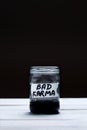 Bad Karma - an inscription on the label of a glass jar with a liquid of black color on a black and white background