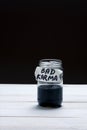 Bad Karma - an inscription on the label of a glass jar with a liquid of black color on a black and white background