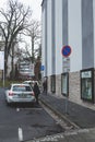 A woman getting off the white Skoda Superb on a car parking in a town in Germany