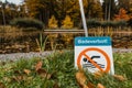 Wonderfull lake in the background with a sign swimming prohibited in the foreground. Royalty Free Stock Photo