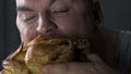 Bad mannered guy biting into fried chicken, food addiction leading to illnesses