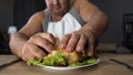 Bad mannered man tearing greasy fried chicken with fingers, fatty food addiction