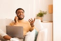 Dissatisfied Man Talking On Phone Sitting With Laptop On Couch Royalty Free Stock Photo