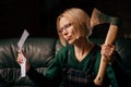 Bad news in a letter. A woman in a rage holds a letter and an ax in her hands. Bad news