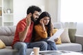 Bad News. Portrait of upset young indian couple reading documents at home Royalty Free Stock Photo
