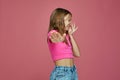 Bad smell. Child girl pinch nose showing stop gesture, feel disgust on pink studio background. Toxic hideous odor Royalty Free Stock Photo