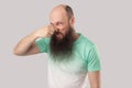 Bad smell. Portrait of confused middle aged bald man with long beard in light green t-shirt standing, blocking his nose and