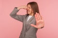 Bad smell! Portrait of confused young woman in business suit pinching her nose and showing stop, frowning in displeasure Royalty Free Stock Photo