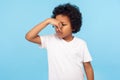 Bad smell. Portrait of displeased confused little boy in T-shirt holding breath, pinching his nose Royalty Free Stock Photo