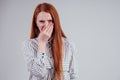 Bad smell unhappy redhead business woman in a striped shirt holding her nose indoor studio shot white background. Royalty Free Stock Photo