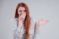 Bad smell unhappy redhead business woman in a striped shirt holding her nose indoor studio shot white background. Royalty Free Stock Photo