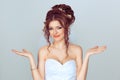 Bad things happens. Bride girl gesturing with both hands confusion i don`t know making funny puzzled face against light blue Royalty Free Stock Photo