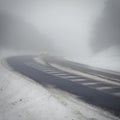 Bad weather driving - foggy hazy country road. Motorway - road traffic. Winter time. Autumn - fall. Snow and frost on the road in
