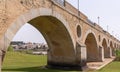 The historic 15-century Puente de Palmas Bridge with a view of the Old Town through one of the arches