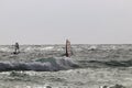 Windsurfers surf the waves at high speed.