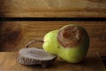 BADLY BLEMISHED PEAR ON A WOODEN SURFACE