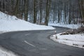 badly damage road with a downhill s-curve in winter forest