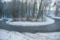badly damage road with a hairpin curve in winter forest Royalty Free Stock Photo