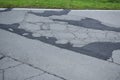 badly damaged road, some potholes repaired Royalty Free Stock Photo