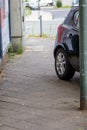 Badly parked car with tire on pavement shows wheel on walkway as traffic violation with penalty for poor driving and parking viola