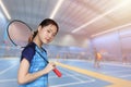 Badminton Athlete Asian player teen girl cute smiling portrait with indoor sport badminton court background Royalty Free Stock Photo