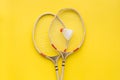 Badminton concept. Badminton rackets and shuttlecock on yellow background top view space for text Royalty Free Stock Photo