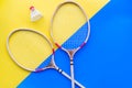 Badminton equipment. Badminton rackets and shuttlecock on yellow and blue background top view copy space Royalty Free Stock Photo