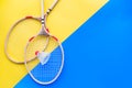 Badminton equipment. Badminton rackets and shuttlecock on yellow and blue background top view copy space Royalty Free Stock Photo