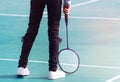 Badminton and racket on court floor.