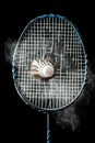 Badminton racket in motion, shuttlecock in action, black background
