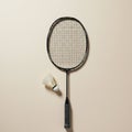 Badminton racket and shuttlecock displayed against a plain beige background. The Royalty Free Stock Photo