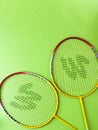 Badminton racket and White Feather Shuttlecock with a colour green background stock isolated image.