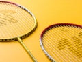 Badminton racket and White Feather Shuttlecock with a colour yellow background stock isolated image.