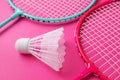 Badminton rackets and shuttlecock on a bright pink background. Royalty Free Stock Photo