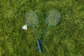 badminton rackets and shuttlecock on grass