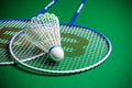 Badminton rackets and shuttlecock on green ground
