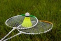 Badminton set yellow shuttlecock and rackets lying on green grass. Sports concept. Royalty Free Stock Photo