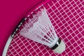 Badminton shuttlecock and racket against a pink background Royalty Free Stock Photo