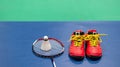 badminton shuttlecock on racket and red shoe on badminton court