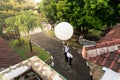 BADUNG/BALI-APRIL 10 2019: An observer at Ngurah Rai Meteorological station releasing the big white radio sonde balloon to measure